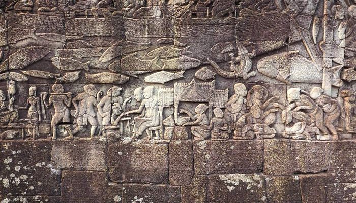 Bas-Relief depicting scenes from everyday life (here: market scene and cock fight), gallery reliefs at Bayon temple, 12th century, Angkor Thom, Cambodia. Photo: Helene Bongers